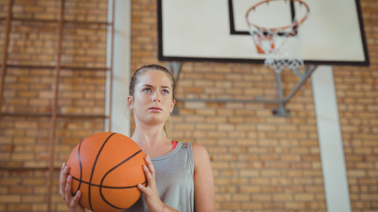 Determined girl holding a basket ball