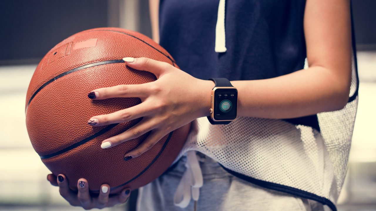 Teenage girl holding a basketball on the court